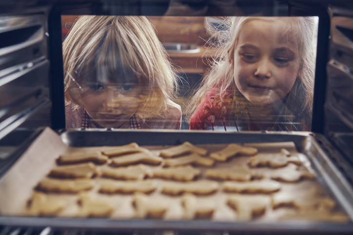 Little Girls Waiting for Christmas Cookies to Bake in the Oven